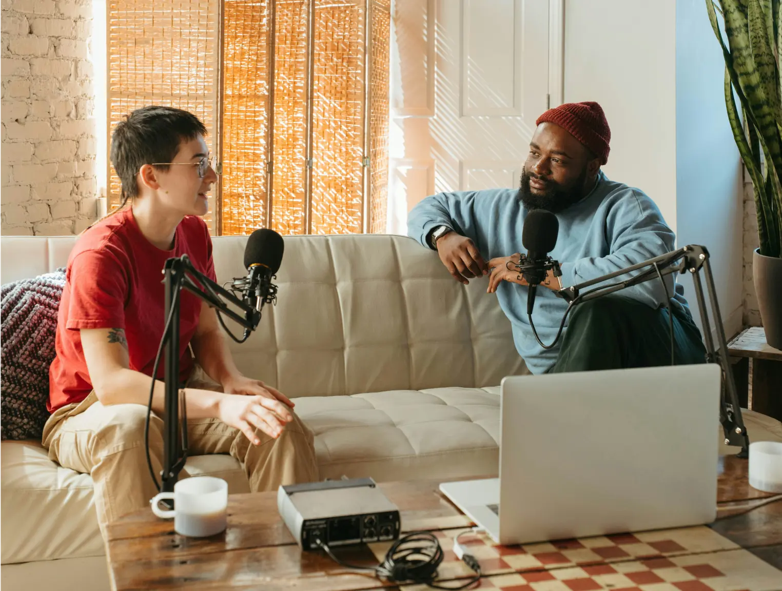Dos personas grabando un podcast en un sofá