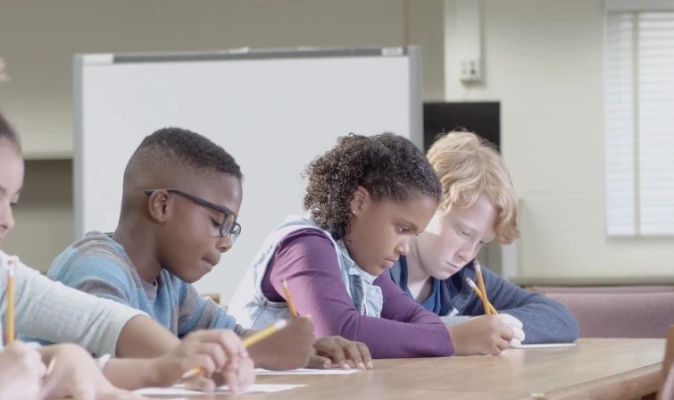 elementary aged children in school writing on papers